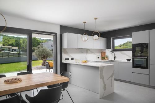 a kitchen with a wooden table and a dining room at Villa Tia in Kukurini - Haus für 8 Personen in Pićan