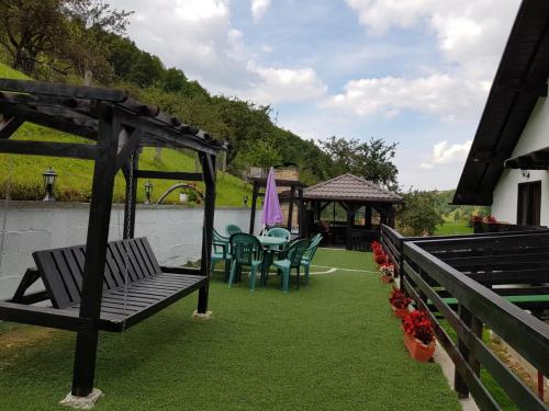 a patio with a table and chairs and a gazebo at Casa din Codru in Şimon