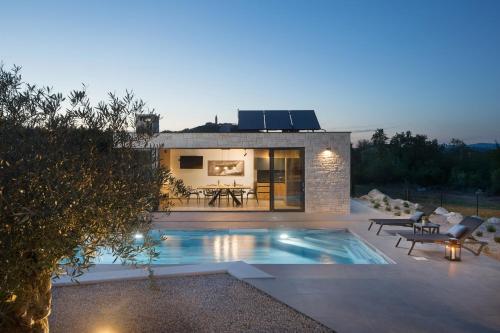 a house with a swimming pool in front of it at Villa Tia in Kukurini - Haus für 8 Personen in Pićan