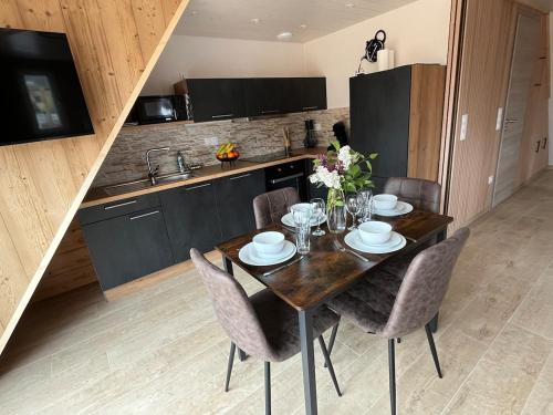 a dining room table with chairs and a kitchen at Gite L'Ecureuillon à coté d'Europapark in Sundhouse
