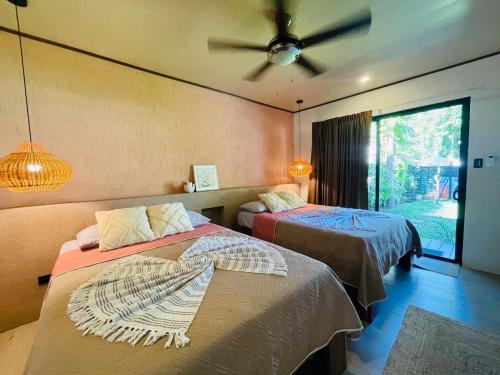 a bedroom with two beds and a ceiling fan at Tropical Private Home for 8pp with pool in Talamanca