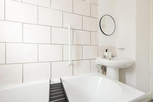a white bathroom with a tub and a sink at 4BR - 8 Beds - Free Parking - Long stay Discounts in Killingbeck