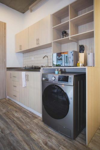 a kitchen with a washing machine in the middle at Enchanted Elegance in Laureles in Medellín