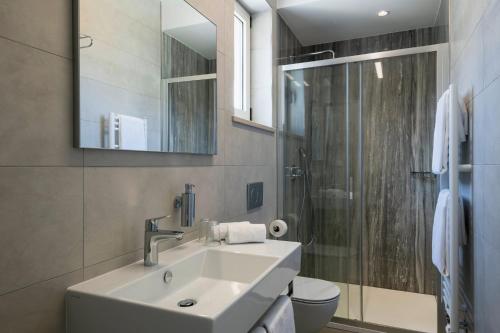a white bathroom with a sink and a shower at Villa Valentina in Krnica - Haus für 8-9 Personen in Krnica