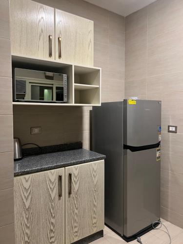 a kitchen with a refrigerator and a microwave at Elite House الصفوة للشقق الفندقية in 6th Of October