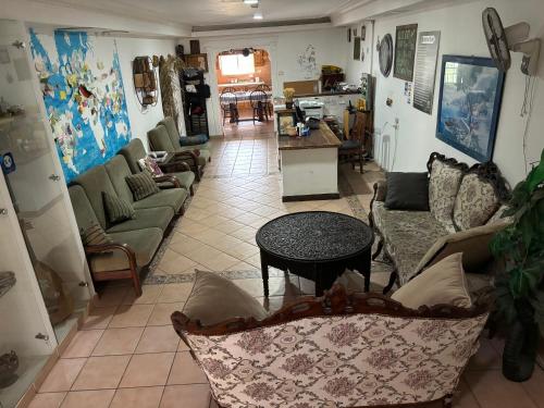 a living room with couches and a table at Al Yakhour Hostel in Haifa