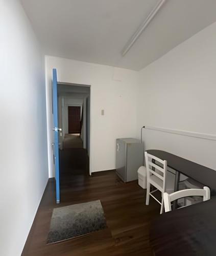 a white room with a table and a chair at Habitación 2 a 3 pers. in Temuco