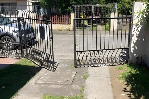 a gate with a car parked next to a house at Habitación 2 a 3 pers. in Temuco