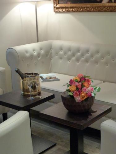 a couch with a table with a bowl of flowers on it at Hotel Rheinischer Hof Bad Soden in Bad Soden am Taunus