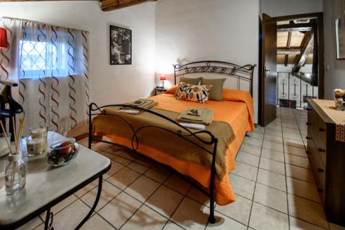 a bedroom with a bed with an orange bedspread at Casa Don Vito in Aci Bonaccorsi