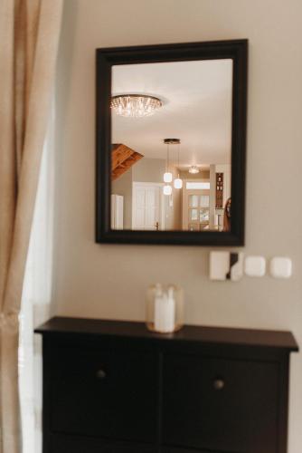 a mirror on a wall above a dresser at Villa Maranga in Dombóvár