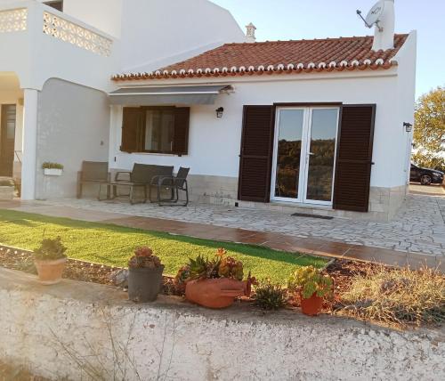a white house with potted plants in front of it at Casa Raios de Sol in Burgau