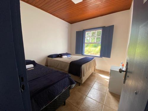 una camera da letto con due letti e una finestra di Casa São José a Tiradentes