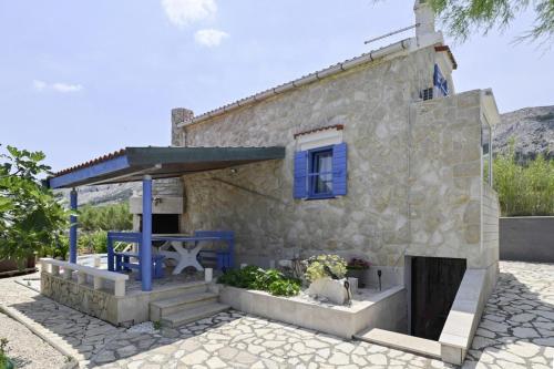 a small stone house with a blue window at Marianna in Pag - Haus für 5 Personen in Pag