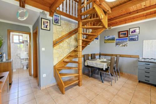 a kitchen and dining room with a wooden spiral staircase at Marianna in Pag - Haus für 5 Personen in Pag