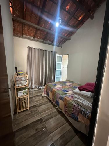 a bedroom with a bed and a wooden floor at Chalé Arco Iris in Esmeraldas