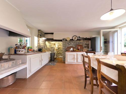 a kitchen with a table and some chairs in a room at Homeby, Casale Bera in Cossano Belbo