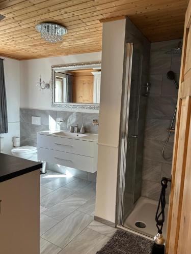 a bathroom with a shower and a sink at Chalet Schluechtyi in Langwies