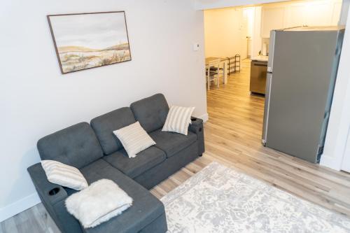 a living room with a couch and a kitchen at Luxury One Bedroom Private Apartment just 7 minutes from the Airport in Dieppe