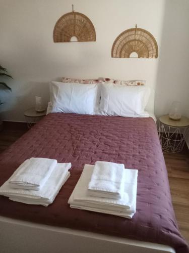 a bedroom with a bed with white towels on it at Casa Raios de Sol in Burgau