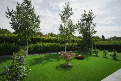 a garden with two trees and green grass at Penzión Skalica in Skalica