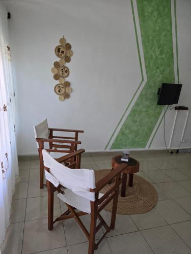 a room with two chairs and a table and a window at Studio Poivre - Séjour tropical à Nosy Be in Madirokely