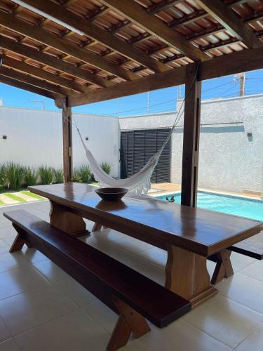 a hammock sitting on a table under a pergola at Casa aconchego in Alcobaça