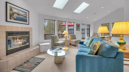 a living room with a blue couch and a fireplace at Shadow - Unit 1 in Sunriver
