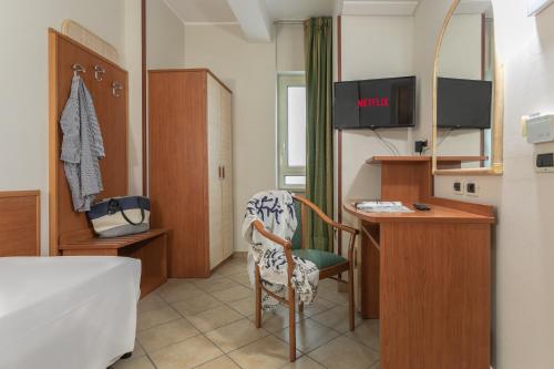 a bedroom with a bed and a desk with a computer at Hotel Prestige in Montesilvano