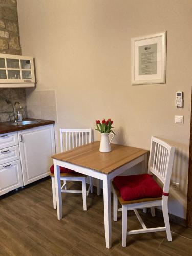 a kitchen with a table and chairs with a vase of flowers at Zsóka Fogadója in Szentantalfa