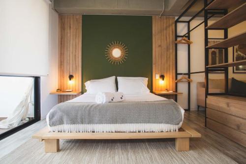 a bedroom with a large bed with a green wall at Enchanted Elegance in Laureles in Medellín