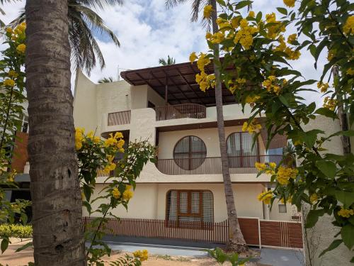a building with two palm trees in front of it at Auric by Hillton in Mysore