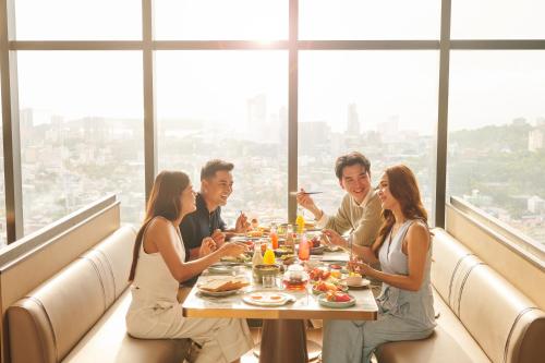 a group of people sitting at a table eating food at TRIMULIA Hotel in Sihanoukville