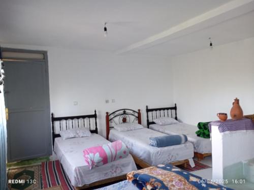 a room with three beds in a room at مأوى الكوف السياحي in M'diq