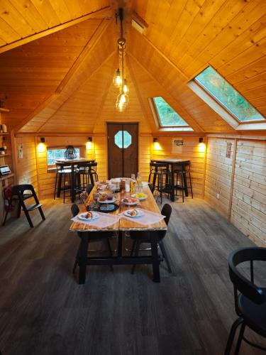 een eetkamer met een grote tafel in een houten kamer bij Étoile du Cians Camping Beuil in Beuil
