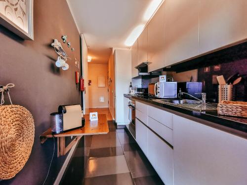 a kitchen with a counter and a sink in it at Bridge View with Balcony By Gt House in Sacavém