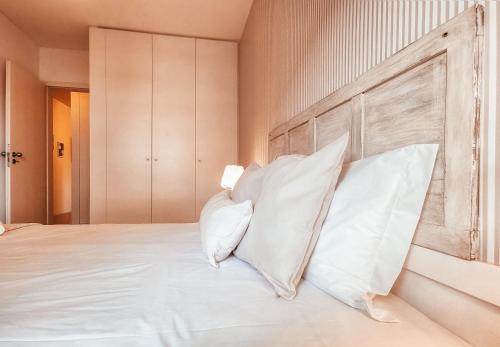 a bedroom with a large bed with white pillows at Bridge View with Balcony By Gt House in Sacavém