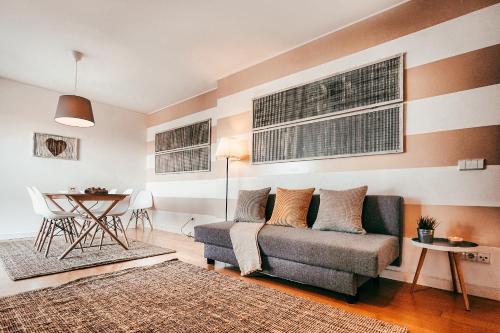 a living room with a couch and a table at Bridge View with Balcony By Gt House in Sacavém