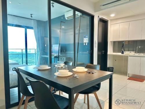 a dining room table and chairs in a kitchen at Almas Suites Puteri Harbour by Stayrene in Nusajaya