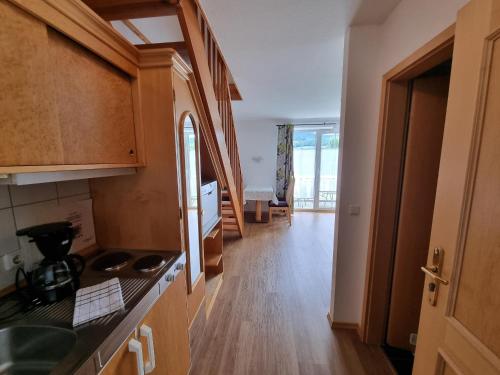 a kitchen with wooden cabinets and a wooden floor at Ferienwohnung Woidtraum in Hohenwarth