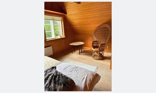 una camera con un letto e una sedia e una finestra di 1652-Hundested-Margeritvej-11 a Kikhavn