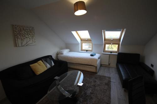 a small living room with a bed and a couch at Holden Court Apartment 5 in West Drayton
