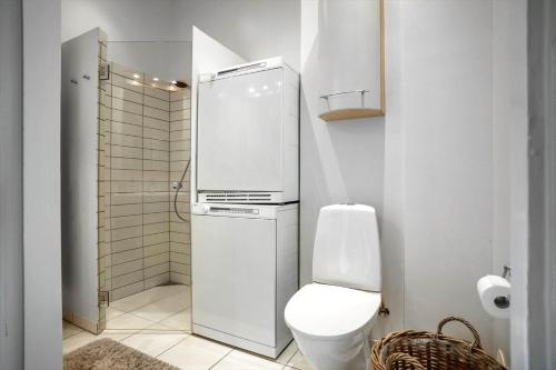 a white bathroom with a toilet and a refrigerator at FY399-Bogense-Ostergade-5-a in Bogense