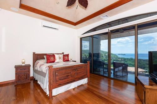 a bedroom with a bed and a large window at Casa De Los Sueos in Playa Hermosa
