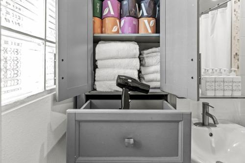 a bathroom with a sink and a shelf with towels at Ground Floor Oceanview Open Tonight Morning Arrival Possible! in Longboat Key