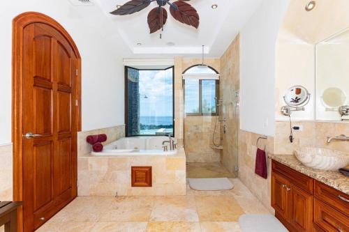 a bathroom with a tub and a shower and a sink at Casa De Los Sueos in Playa Hermosa