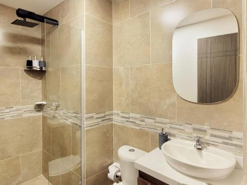 a bathroom with a toilet and a sink and a mirror at The Hub by Wynwood House in Medellín