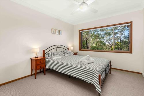 a bedroom with two beds and a window at Blenheim Hideaway by Experience Jervis Bay in Vincentia