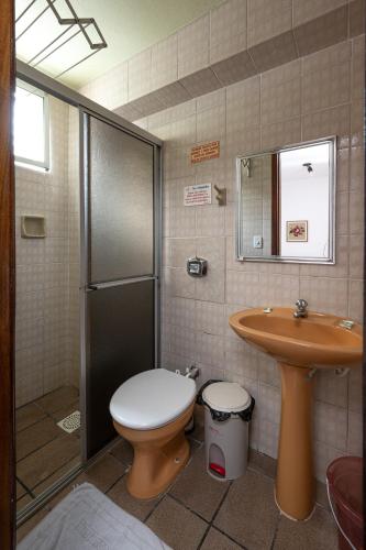 a bathroom with a toilet and a sink and a shower at Pousada Canto das Pedras in Bombinhas