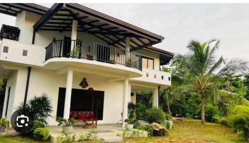 a house with a balcony on the side of it at Seekku Villa in Balapitiya